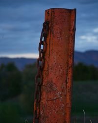 Close-up of rusty metal chain against sky