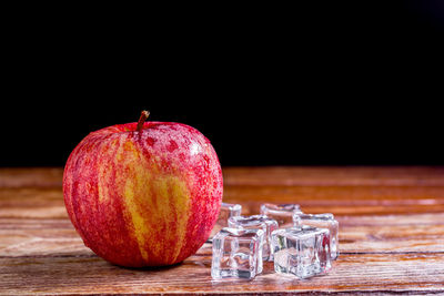 Close-up of apple on table against black background