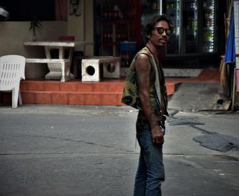 Side view of young man standing on street