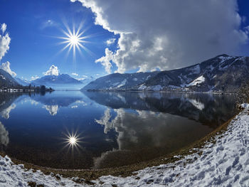 Scenic view of frozen lake and mountains against sky