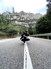 Woman on road in city against sky