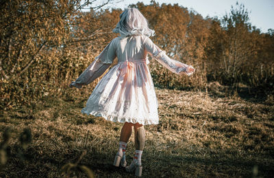 Rear view of boy on field in forest