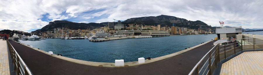 Panoramic view of sea by city buildings against sky