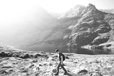 Man standing on cliff against mountain range