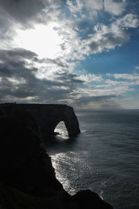 Rock formation in sea against sky