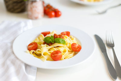 Fresh italian pasta with cherry tomatoes, cheese and basil. vegetarian spaghetti. healthy food.