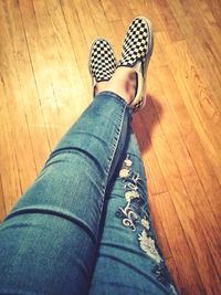 Low section of woman relaxing on hardwood floor