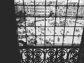 High angle view of people on town square seen through window