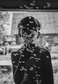 Portrait of woman standing by tree in city