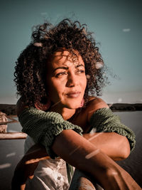 Portrait of beautiful young woman against sky