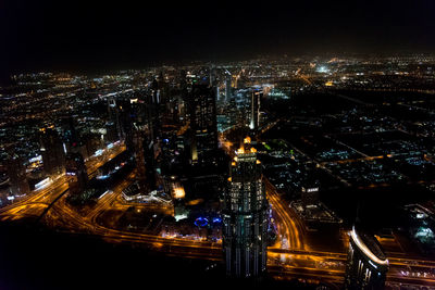 Illuminated cityscape against sky at night