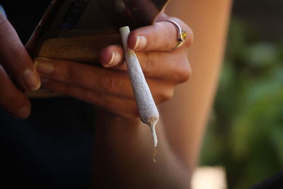 Close-up of woman hand holding cigarette