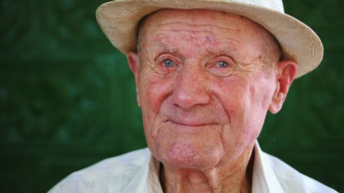 Close-up portrait of senior man wearing hat