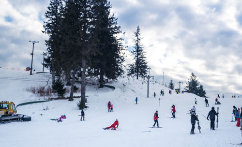 People enjoying on snow covered landscape