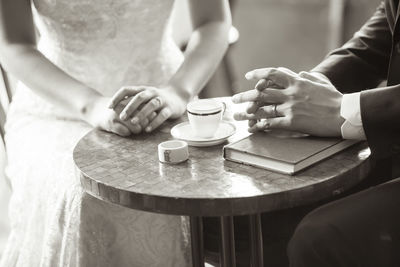 The two hands on the table of a newlywed couple who are about to get married.