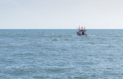 Sailboat sailing on sea against clear sky