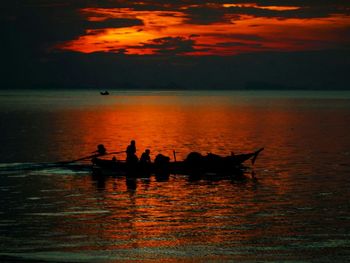 Boat sailing in sea at sunset