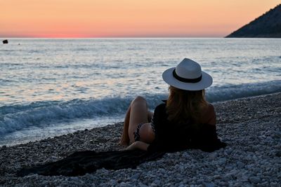 Rear view of woman on beach during sunset