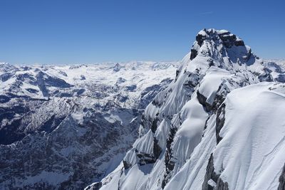 Scenic view of snowcapped mountains against clear blue sky