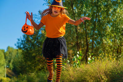 Cute girl wearing halloween costume standing on road