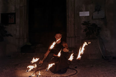 People sitting on log at night