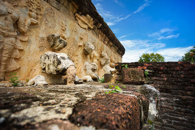 Low angle view of old stone wall against sky