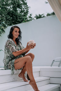 Portrait of a smiling young woman sitting outdoors