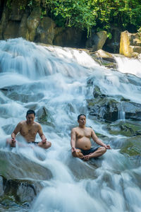 Full length of shirtless young man in water