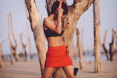 Woman standing on tree trunk