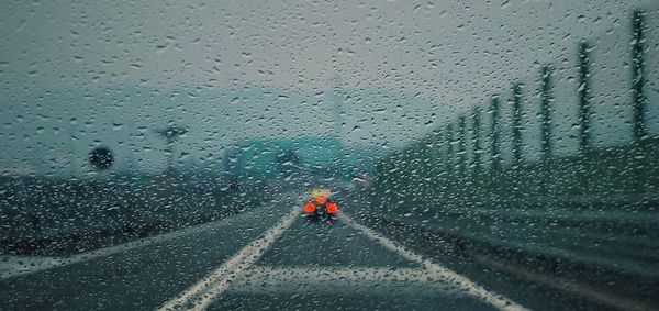 Road seen through wet windshield during rain