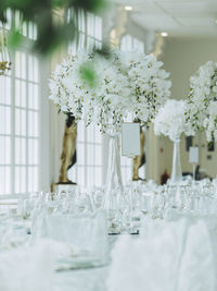 Bouquet with wineglasses arranged on table in hotel during wedding party