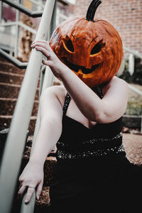 Portrait of woman wearing a pumpkin head