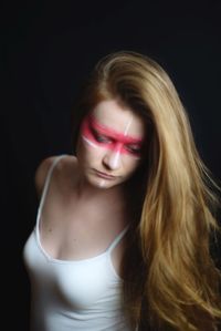 Portrait of beautiful woman against black background