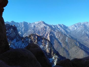 Scenic view of snowcapped mountains against clear blue sky