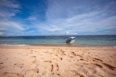 Boat moored at sea against sky