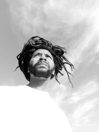 Low angle view of man with dreadlocks against sky