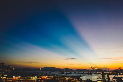 Silhouette city against blue sky at sunset