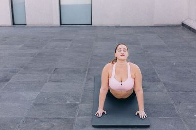 Full length of a young woman doing yoga on floor