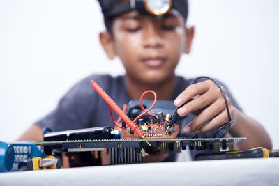 Young schoolboy learning electronic circuit board. detail focus on board component
