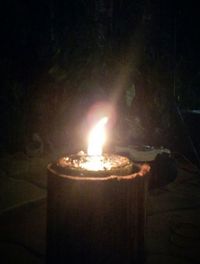 Close-up of lit candle in dark room