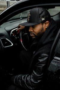 Side view of young man in car