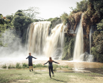 Couple in front of the waterfall in carrancas, minas gerais