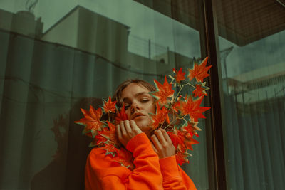 Portrait of woman holding red flower