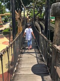 Rear view of a woman walking on boardwalk