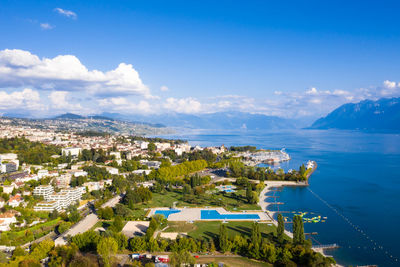 High angle view of city by sea against sky