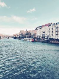 Scenic view of canal by buildings against sky