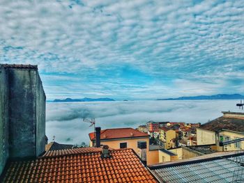 Houses against cloudy sky