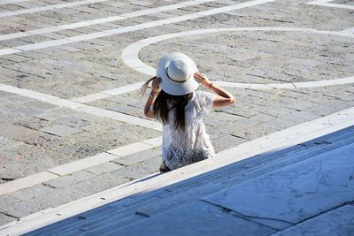 Rear view of young woman standing in swimming pool