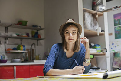 Portrait of young woman sitting on table