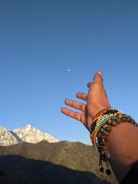 Midsection of man against mountain against clear blue sky